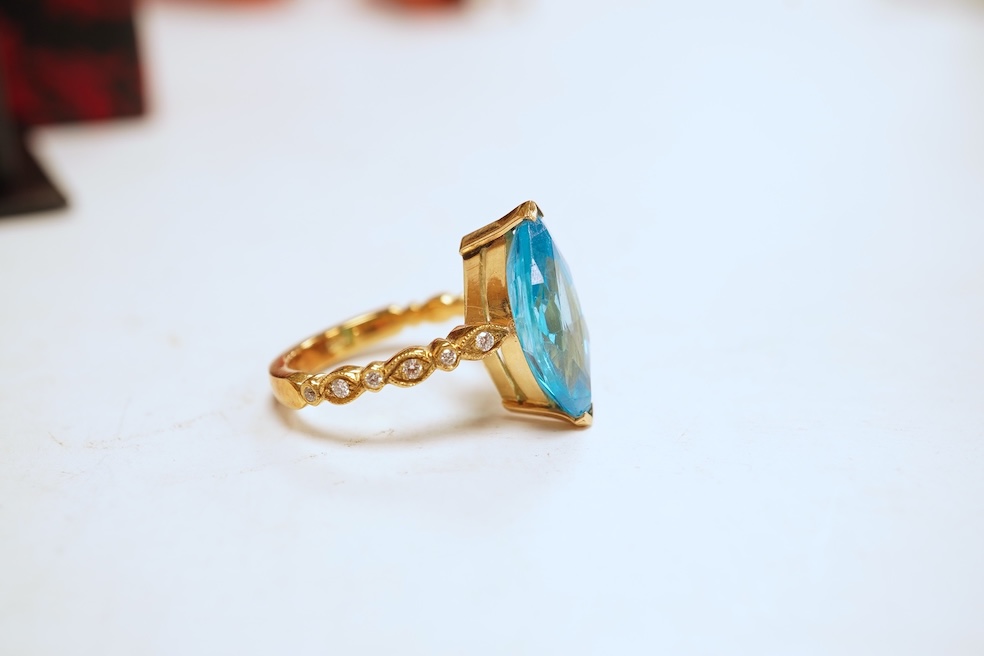 A cubic zirconia and diamond ring, set with a marquise-shaped blue cubic zirconia, to shoulders set with brilliant-cut diamonds, mounted in gold, size Q1/2, stamped 585, gross weight 8 grams, Condition: minor discolorati